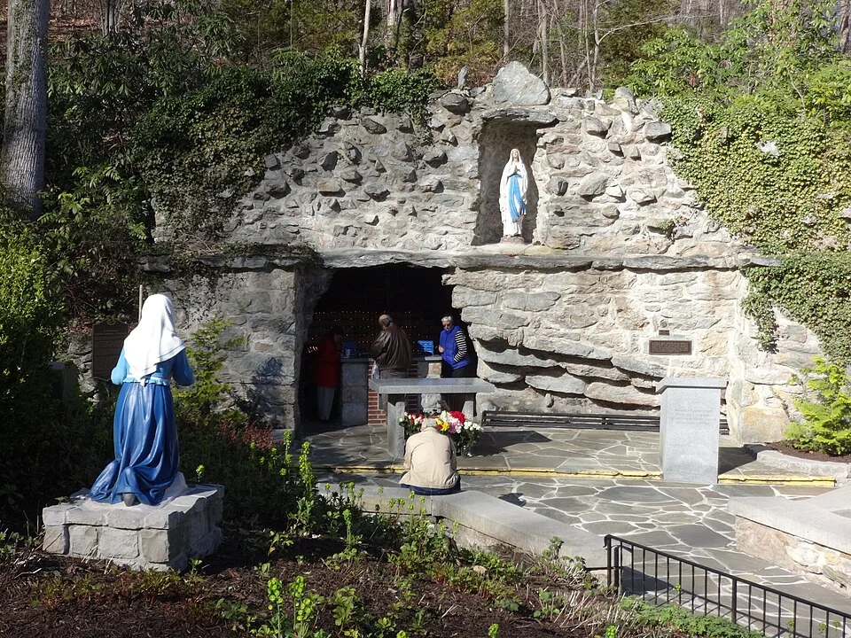 The stone Lourdes grotto at the National Shrine in Emmitsburg with visitors and statues